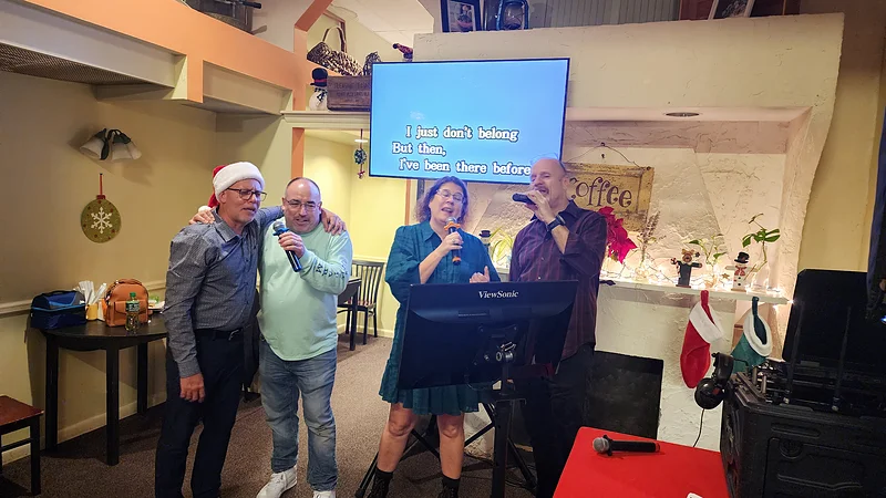 Guests singing together during karaoke entertainment booked for the event, following the lyrics screen